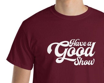 May include: A maroon t-shirt with white text that reads "Have a Good Show" in a retro font.