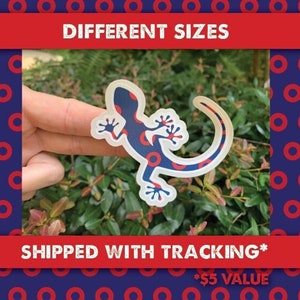May include: A blue and red gecko sticker with a donut pattern. The sticker is on a finger and the background is a blue and red donut pattern.