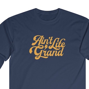 May include: Navy blue long-sleeve t-shirt with the text "Ain't Life Grand" in a yellow retro font.