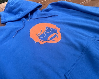 May include: A royal blue hoodie with an orange silhouette of a person wearing sunglasses.