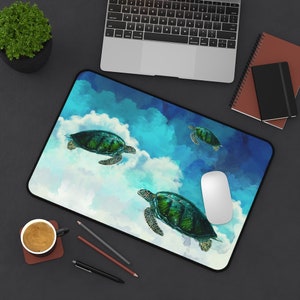 May include: A blue and green mousepad with a watercolor design of three sea turtles swimming in the clouds. The mousepad has a white computer mouse on it.