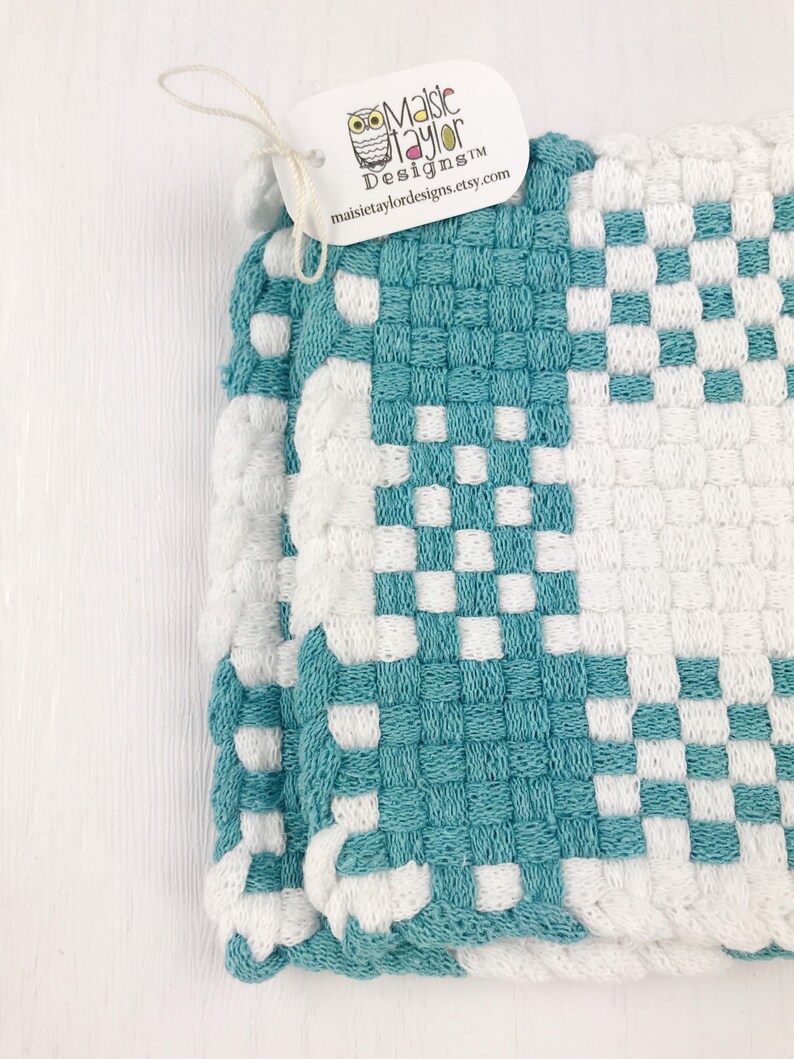 May include: A teal and white woven potholder with a checkerboard design. The tag attached reads "Maisie Taylor Designs" and the website maisietaylordesigns.etsy.com.