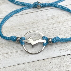 Peut inclure: Un bracelet d'amitié bleu turquoise avec un charme argenté en forme de péninsule supérieure du Michigan.
