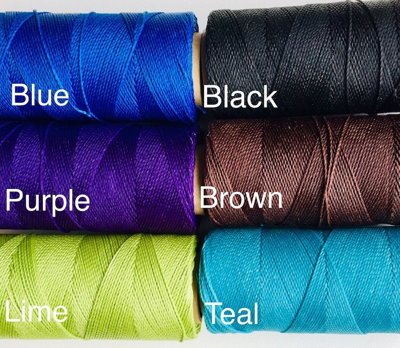 May include: Five spools of thread in different colors: blue, purple, brown, lime green, and teal. The spools are labeled with the color names.