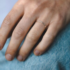 Op de afbeelding: Een eenvoudige, dunne gouden ring gedragen aan een vinger.
