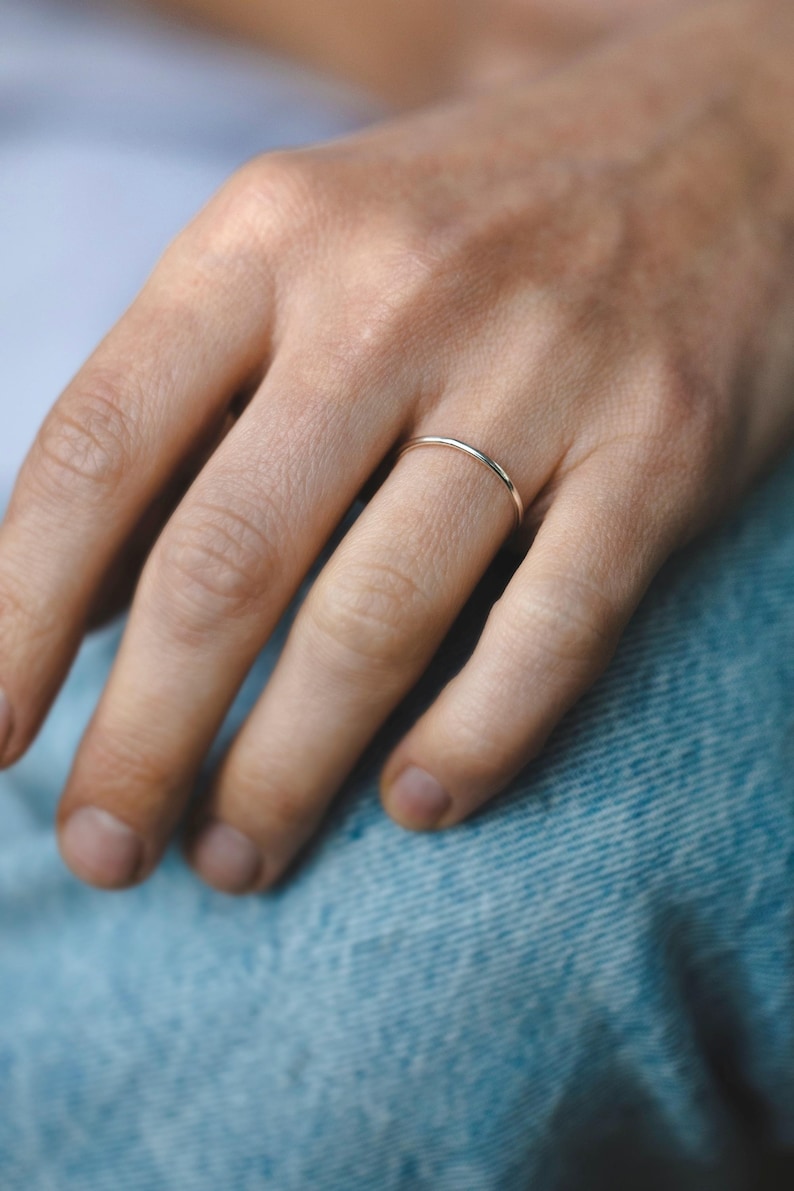 Op de afbeelding: Een eenvoudige, dunne gouden ring gedragen aan een vinger.
