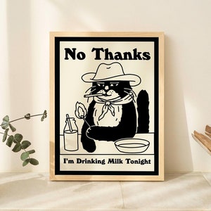 May include: A black and white illustration of a cat wearing a cowboy hat and holding a lit match. The cat is sitting at a table with a glass of milk and a bowl. The text "No Thanks I'm Drinking Milk Tonight" is printed below the cat.