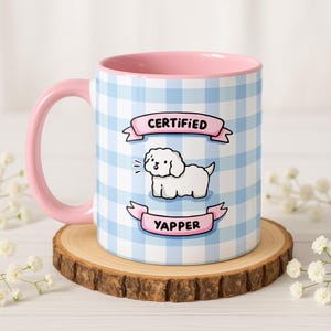 Puede incluir: Taza de cerámica con asa e interior rosas, con un estampado de cuadros vichy azul y blanco. La taza tiene una ilustración de dibujos animados de un perro blanco con el texto "CERTIFIED YAPPER" en pancartas.