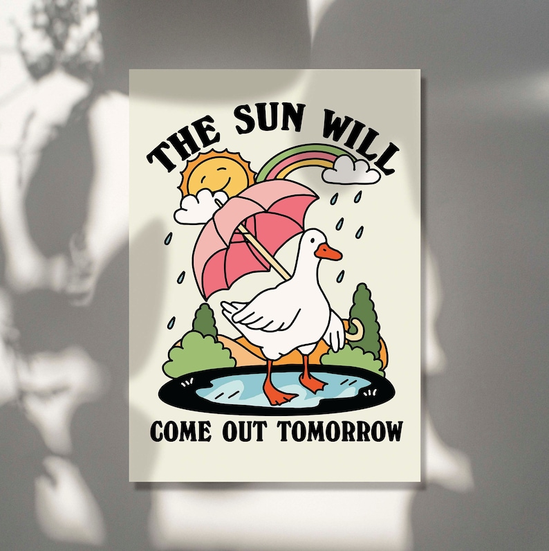 Op de afbeelding: Een witte gans met een roze paraplu loopt door een plas. De tekst "THE SUN WILL COME OUT TOMORROW" staat onder de gans.