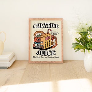 May include: A framed print with a retro illustration of a cartoon orange juice carton with a brain inside. The text reads "Creative Juice: The Best Cure for Creative Block".
