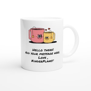 May include: White ceramic mug with a pink and yellow cartoon teacup design. The teacups have faces and are holding hands. The text on the mug reads "Hello there! Add your message here. Love, Kinderplanet."