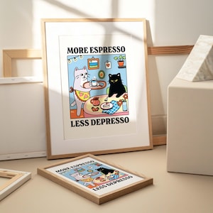 May include: A framed print with a cartoon illustration of two cats. The white cat is holding a tray with a cup of coffee. The black cat is sitting at a table with a slice of cake. The text on the print reads "More Espresso Less Depresso".
