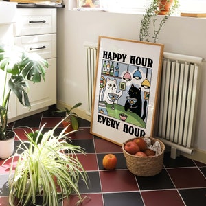 Peut inclure: Une impression encadr&eacute;e avec une illustration en noir et blanc de deux chats dans un bar. Le texte sur l'impression est "Happy Hour Every Hour".