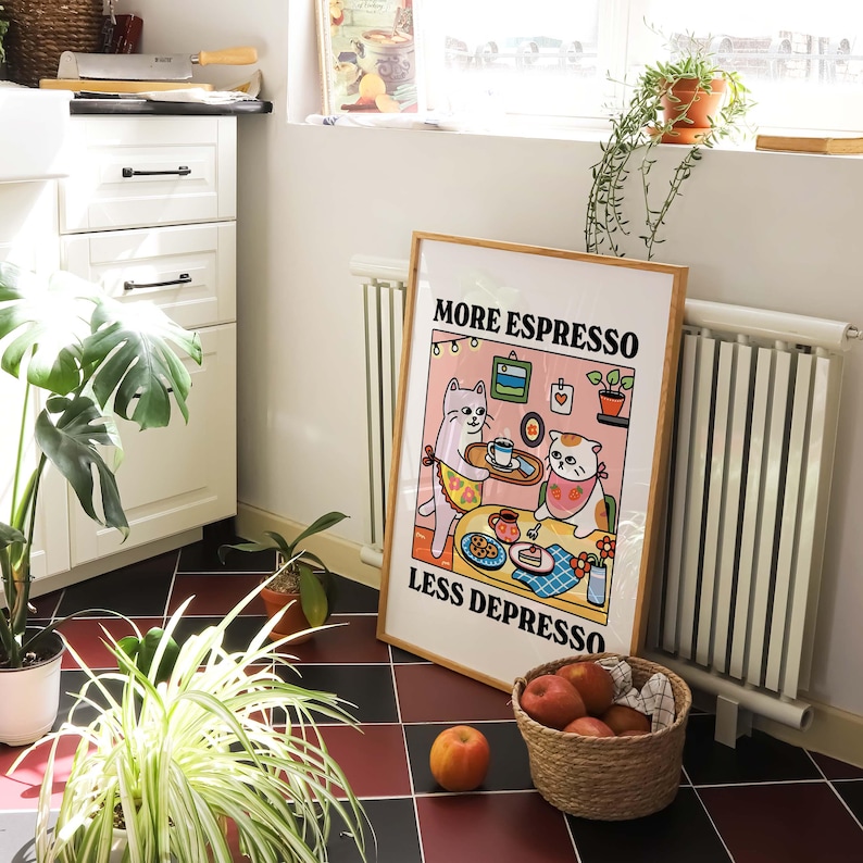 May include: A white poster with a cartoon illustration of two cats drinking coffee. The poster has the text "More Espresso Less Depresso" in black letters.