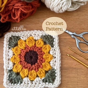 May include: A crocheted sunflower square with yellow, orange, and brown petals, surrounded by green leaves and a cream-colored border. The image includes various yarn colors and the text "Crochet Pattern".