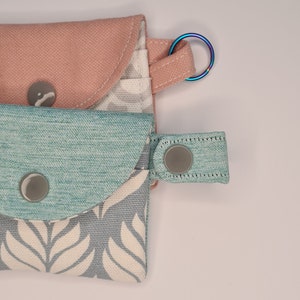 close view to a keyring and the snap strap of the mini card wallets