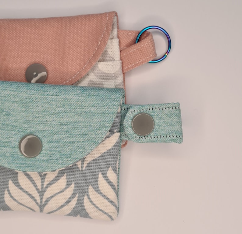 close view to a keyring and the snap strap of the mini card wallets