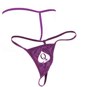 May include: Purple satin thong with a white spade and the letter "Q" in the center.