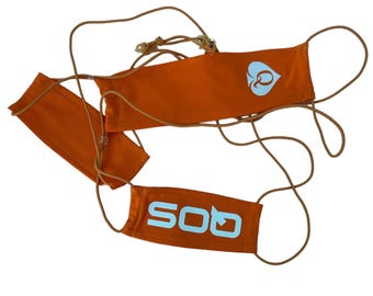 May include: Two orange rectangular fabric face masks connected by thin tan elastic cords. One mask features a light blue spade symbol with the letter Q inside, while the other mask displays the light blue text "SOQ" in a bold, sans-serif font.