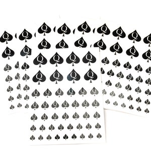 May include: A sheet of stickers with black queen of spades symbols on a white background. The stickers are arranged in rows and columns, with the symbols getting smaller as they go down the sheet.