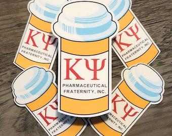 May include: A collection of stickers featuring a pill bottle design. The stickers are yellow with a white cap and a red "KY" symbol and text that reads "PHARMACEUTICAL FRATERNITY, INC."