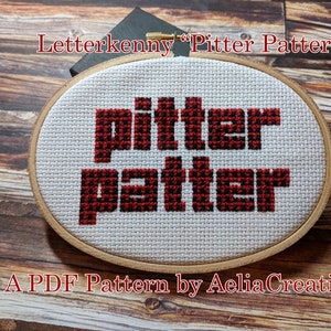 May include: Cross-stitch embroidery in an oval wooden hoop. The design features the words "pitter patter" in red block letters on a white background. The text "Letterkenny" and "A PDF Pattern by AeliaCreations" are also visible.