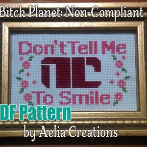 May include: Cross-stitch art in a gold frame. The text reads "Don't Tell Me To Smile" in pink, with a stylized design. The words "Bitch Planet: Non-Compliant" and "PDF Pattern by Aelia Creations" are also visible.