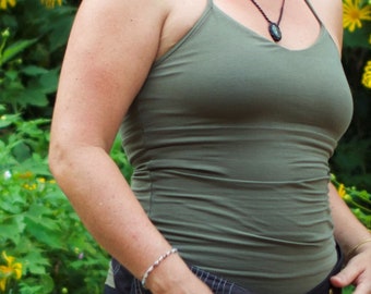 May include: A woman wearing a green tank top with a black strap necklace and a dark green stone pendant.