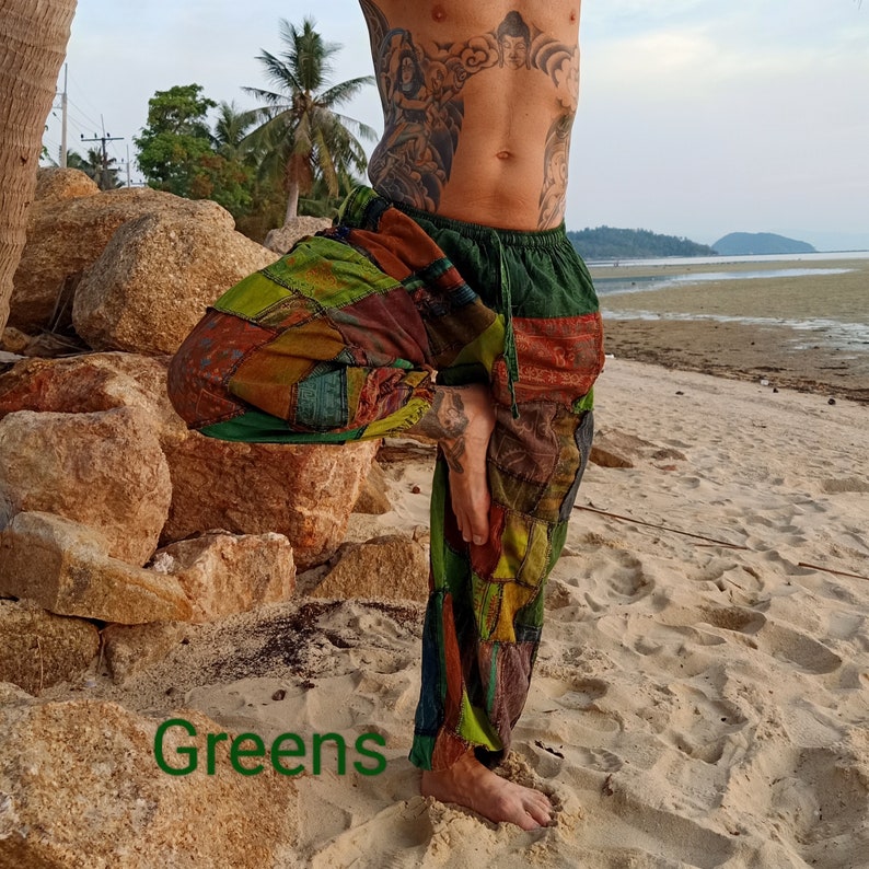 May include: Patchwork pants in shades of green, brown, and orange. The pants have a drawstring waist and a relaxed fit. The word "Greens" is written in green at the bottom of the image. The pants are worn on a beach.