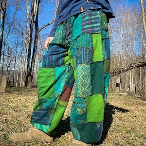 May include: Patchwork pants in shades of green, teal, and blue. The pants feature a variety of patterned patches, creating a unique and colorful design. The loose-fitting pants are made of a soft fabric, perfect for casual wear.