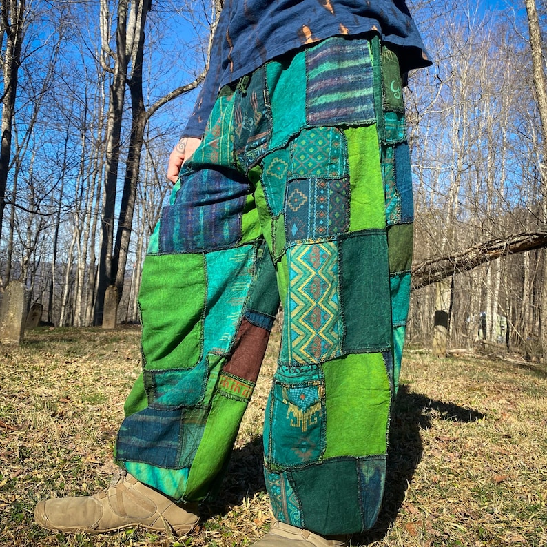 May include: Patchwork pants in shades of green, teal, and blue. The pants feature a variety of patterned patches, creating a unique and colorful design. The loose-fitting pants are made of a soft fabric, perfect for casual wear.