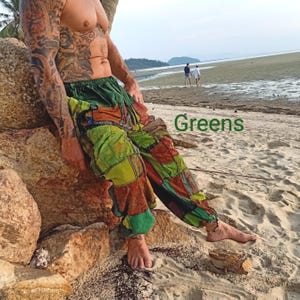 May include: Patchwork pants in shades of green, orange, and brown. The pants have a loose, comfortable fit and are made of various fabric squares sewn together. The word "Greens" is written in green on the image.
