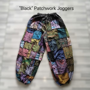 May include: Black patchwork joggers with a drawstring waist. The pants are made of various colorful fabric squares, including shades of blue, green, purple, and pink. The text "Black" Patchwork Joggers is at the top of the image.
