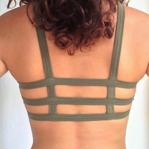 May include: A green sports bra with a criss-cross back design.