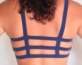 May include: A navy blue sports bra with a criss-cross back design.