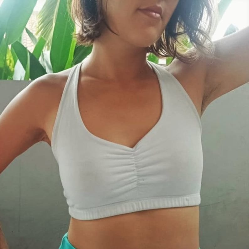 Pu&ograve; includere: Reggiseno sportivo bianco con scollo rotondo e un dettaglio arricciato sul davanti. Il reggiseno &egrave; realizzato in un tessuto morbido ed elastico.