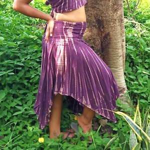 May include: A purple and white tie-dye skirt with a high waist and a flowing, asymmetrical hemline.