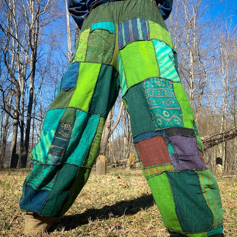 May include: Patchwork pants in shades of green, teal, and blue. The pants feature a variety of fabric patterns and textures, with a loose, comfortable fit. The design includes multiple pockets and a wide waistband, perfect for casual wear.