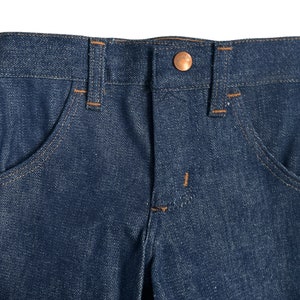 May include: A pair of blue denim jeans with a copper button and stitching detail.