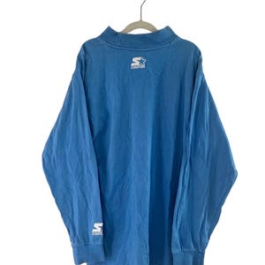 May include: A blue long-sleeved shirt with a white "Starter" logo on the back and a white "S" logo on the left sleeve.