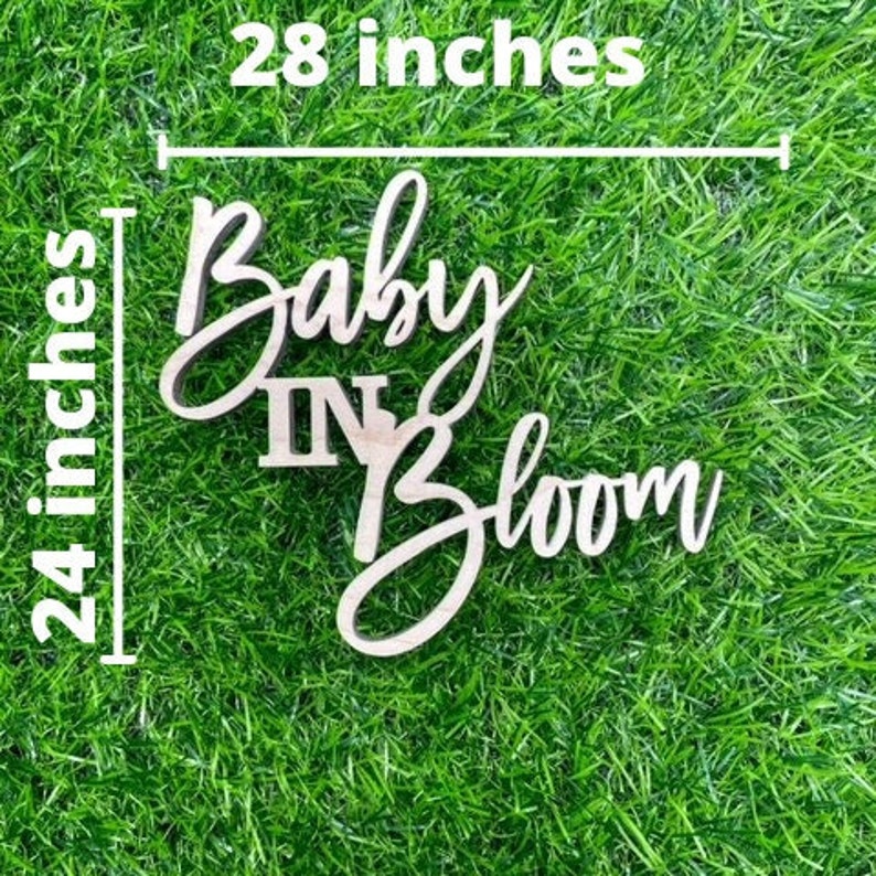 K&ouml;nnte beinhalten: Holzschilder mit dem Text "Baby In Bloom" in einer kursiven Schrift. Das Schild ist 71 cm breit und 61 cm hoch.