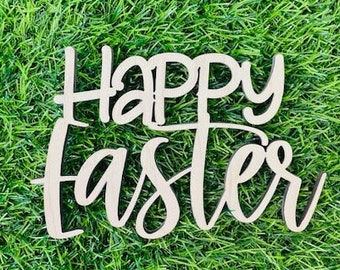 May include: A wooden sign with the words "Happy Easter" in a cursive font. The sign is light-colored and sits on a bed of green grass. The letters are connected, creating a decorative Easter-themed item.