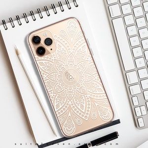 May include: A clear phone case with a white mandala design. The case is designed for a smartphone with a triple camera system.