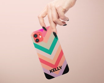 May include: A colorful phone case with a chevron pattern in shades of pink, orange, green, and blue. The case has the name "KELLY" printed in black letters on the bottom.