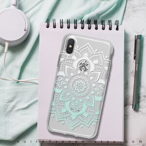May include: A clear phone case with a white and light blue mandala design. The case is designed for an iPhone X.
