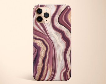 May include: A phone case with a pink and gold marble design. The case has a raised camera bump and a cutout for the phone's charging port.