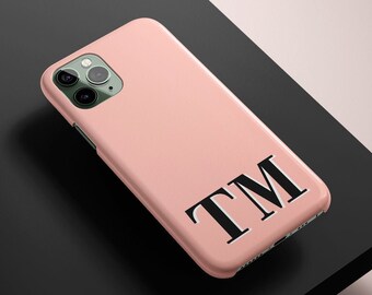 May include: A pink phone case with the initials "TM" in black.