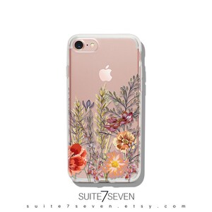 May include: A clear phone case featuring a floral design. The flowers are in shades of red, orange, yellow, and pink. The case is designed for an iPhone.