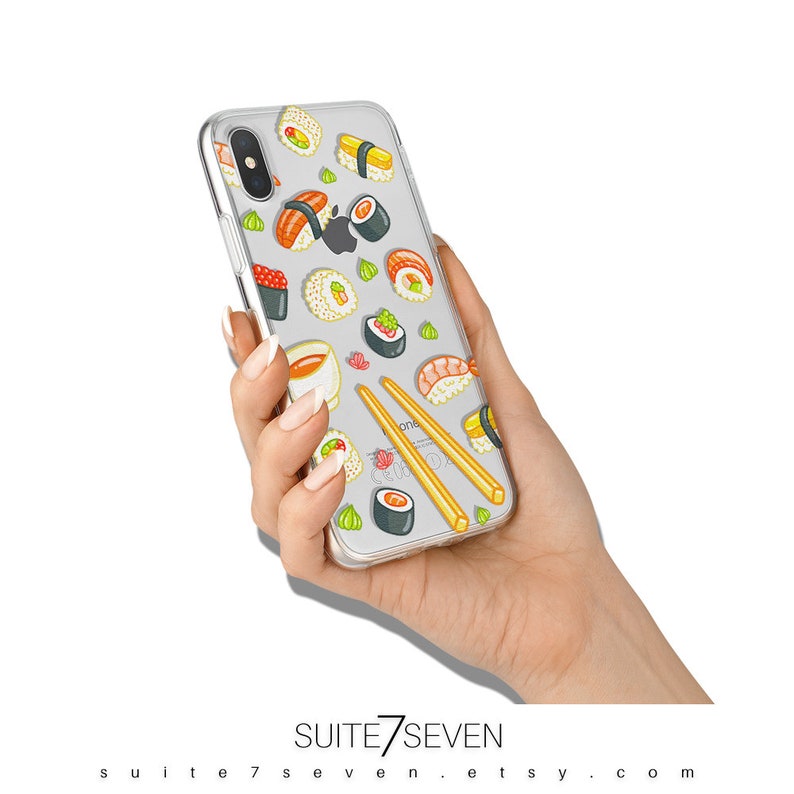 Puede incluir: Funda transparente para tel&eacute;fono con un dise&ntilde;o de sushi colorido, con varios rollos, salsa de soja y palillos. La funda est&aacute; dise&ntilde;ada para un iPhone e incluye el logotipo de Apple. El texto "SUITE7SEVEN" y la URL de la tienda Etsy son visibles.
