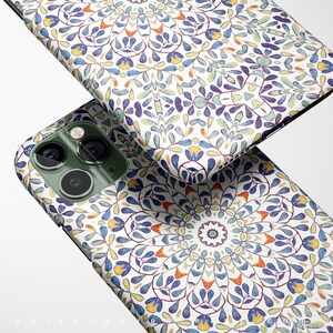 May include: A white phone case with a colorful mandala pattern. The case has a green camera bump with two lenses.